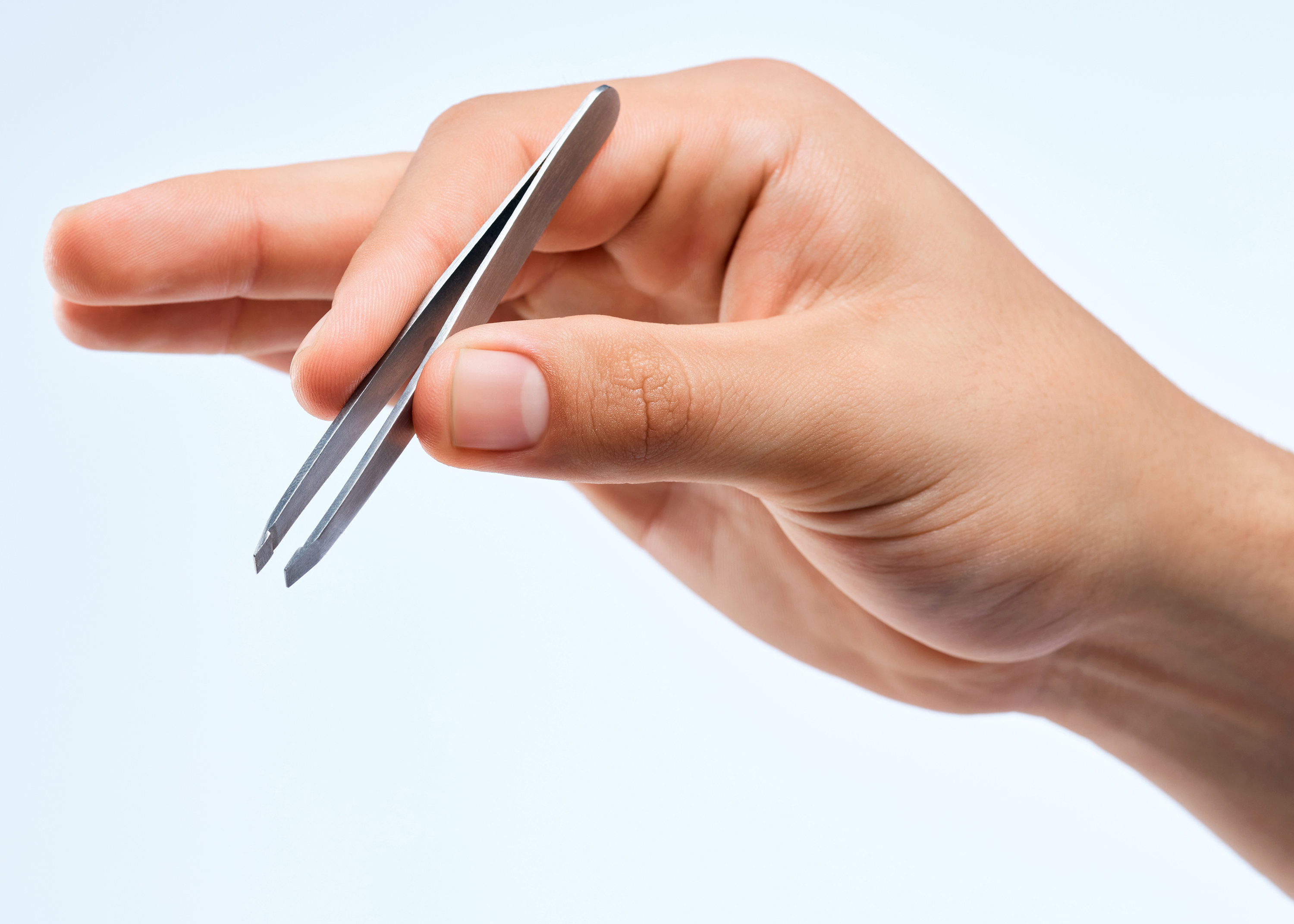 A person holding a pair of tweezers in their hand