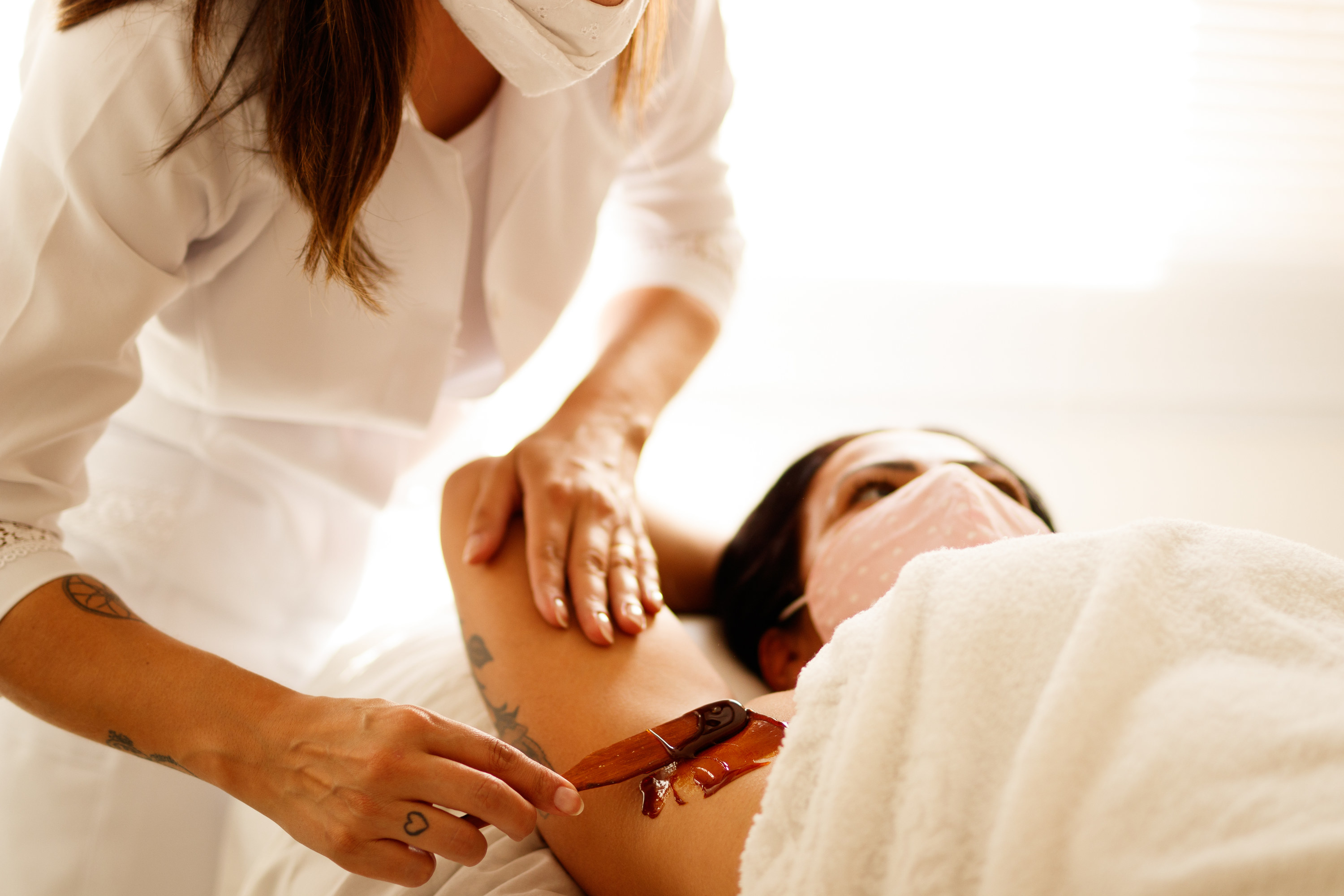 A woman getting her armpits waxed