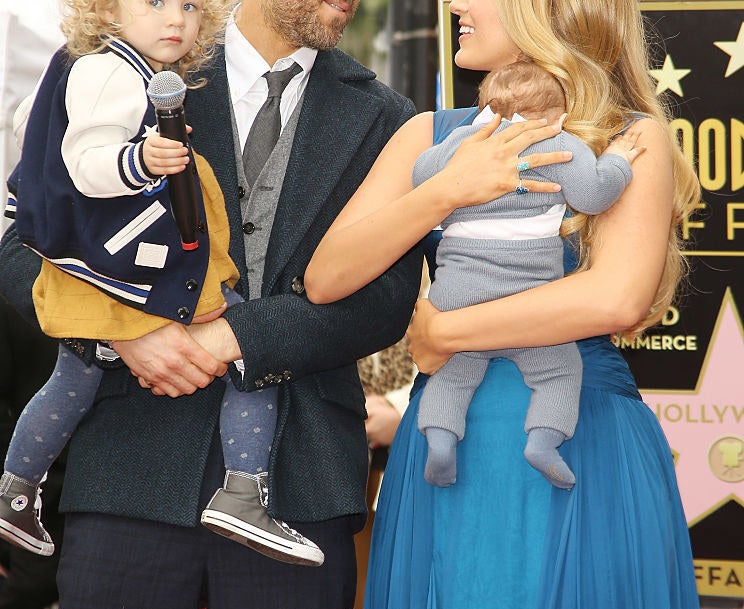 Blake Lively and Ryan Reynolds each holding one of their children