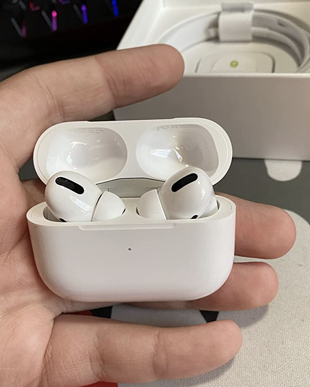 Reviewer holding the AirPods Pro 