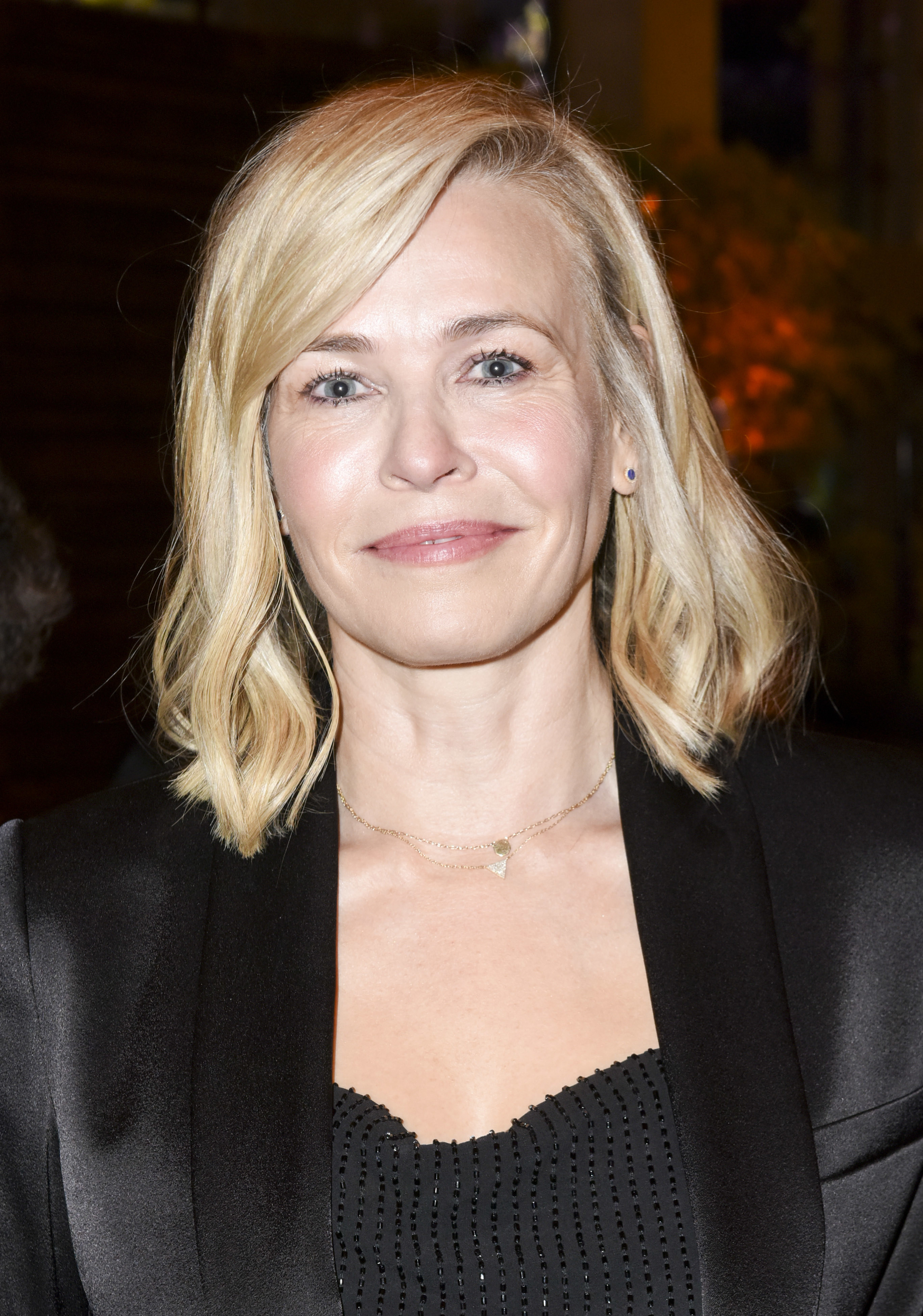 Chelsea Handler, wearing black, poses at an event