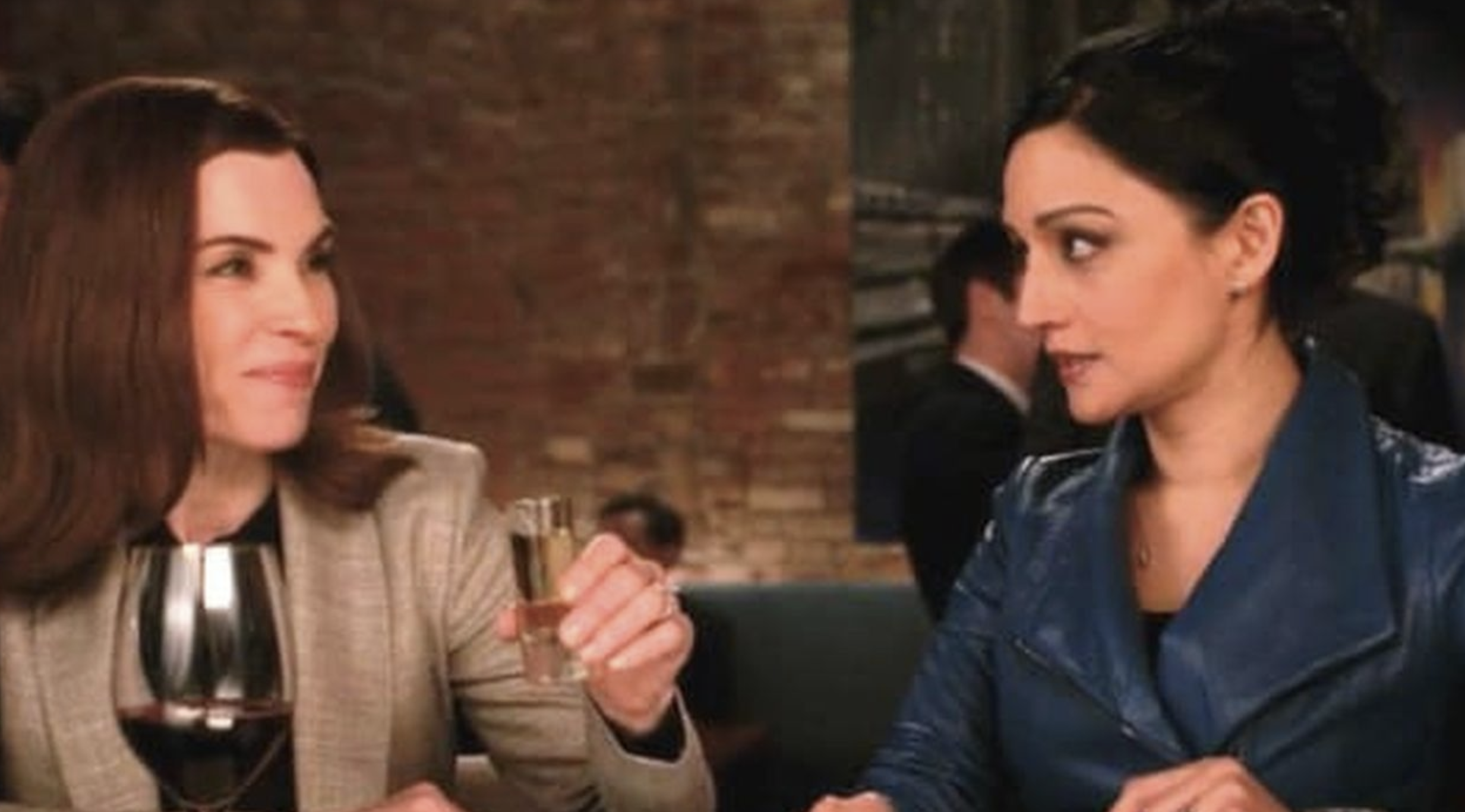 A screenshot of Julianna Margulies and Archie Panjabi sitting next to eachother at a bar in a scene from The Good Wife
