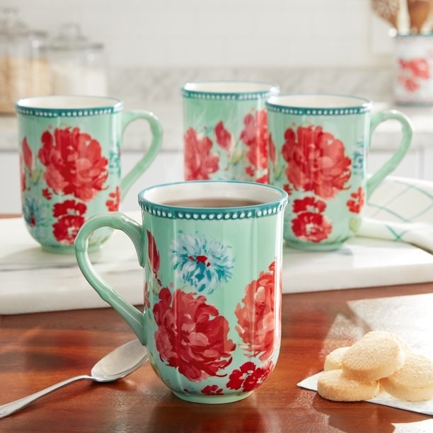 Four floral patterned mugs on a kitchen counter