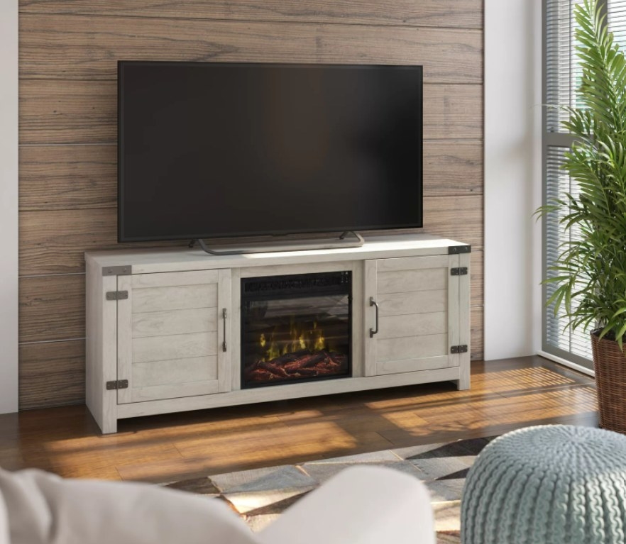 A white wooden TV stand with storage cabinet and electric fireplace with heater