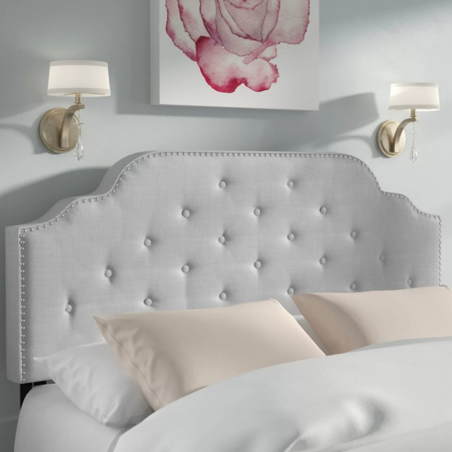 A tufted upholstered headboard with nailhead trim