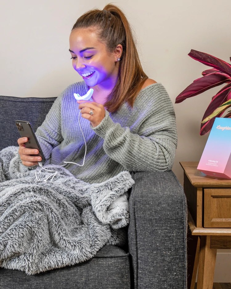 model holds glowing mouthpiece connected to their phone