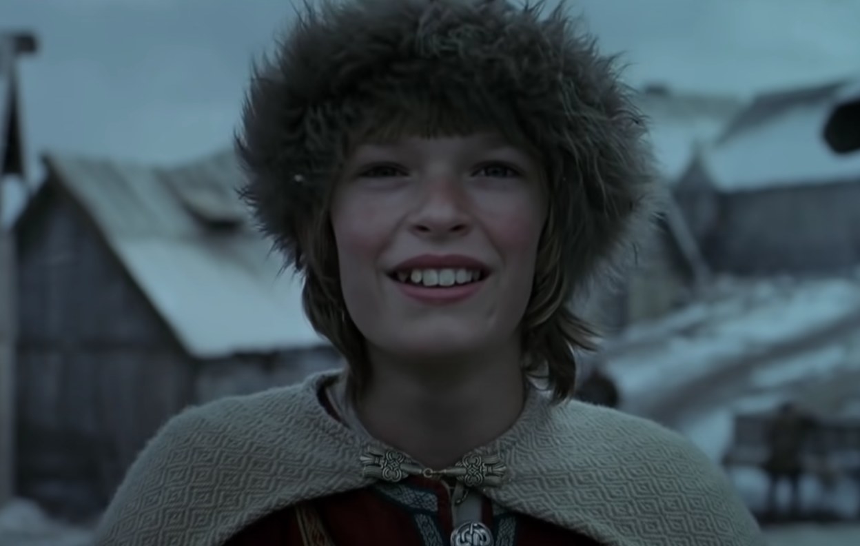 A young viking boy smiling into the distance
