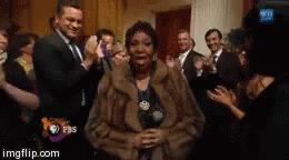 Aretha Franklin walking through a crowd.