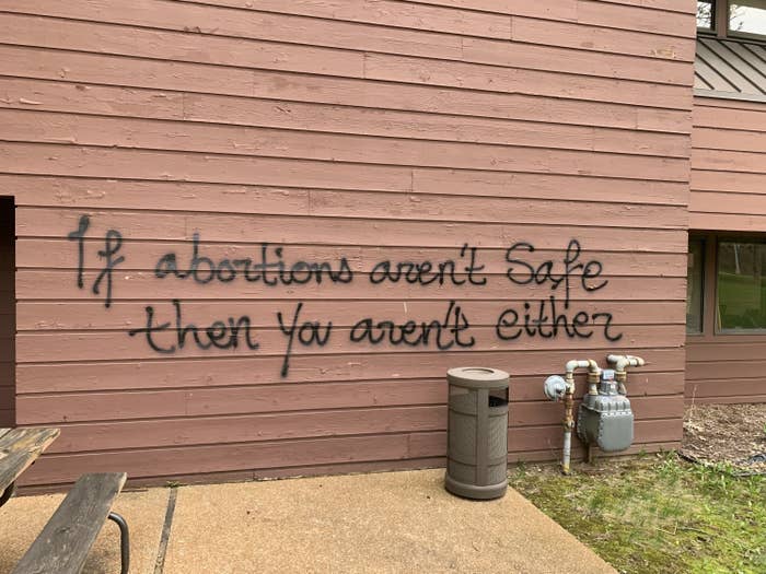 Graffiti on an exterior wall reads "If abortions aren't safe then you aren't either"