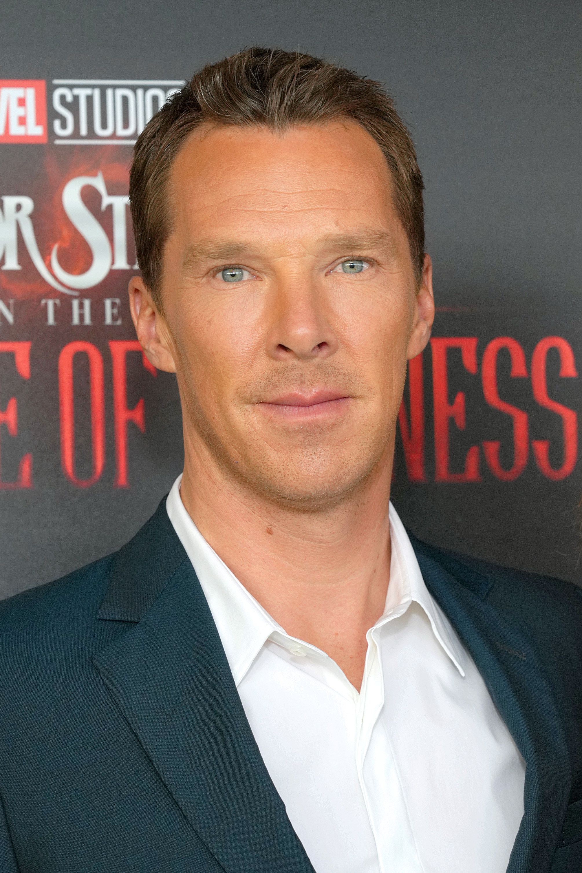 Benedict Cumberbatch on the red carpet in a open-collar white shirt and blue jacket