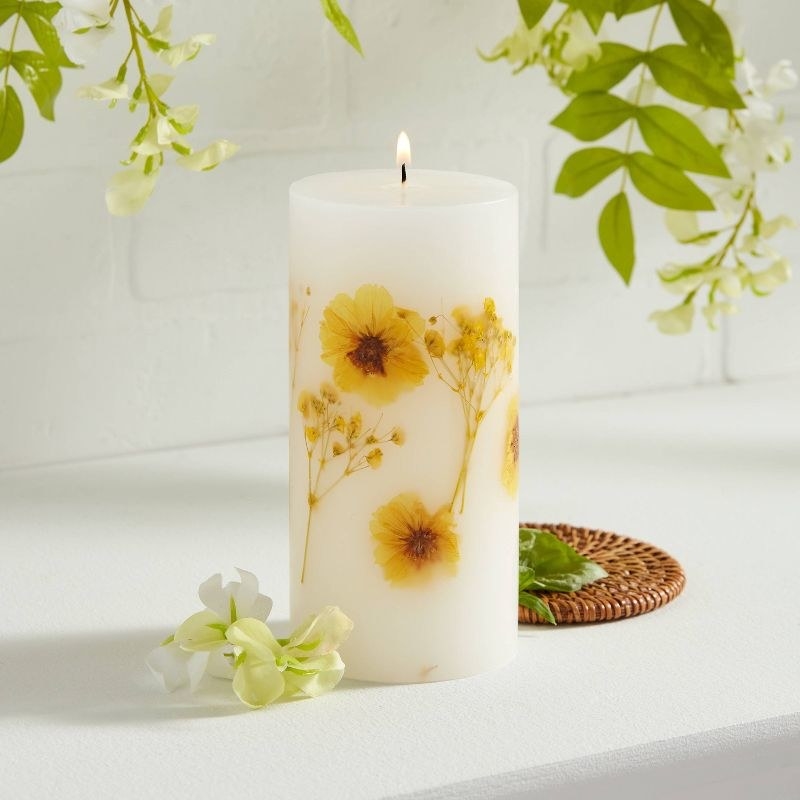 a white pillar candle with flowers