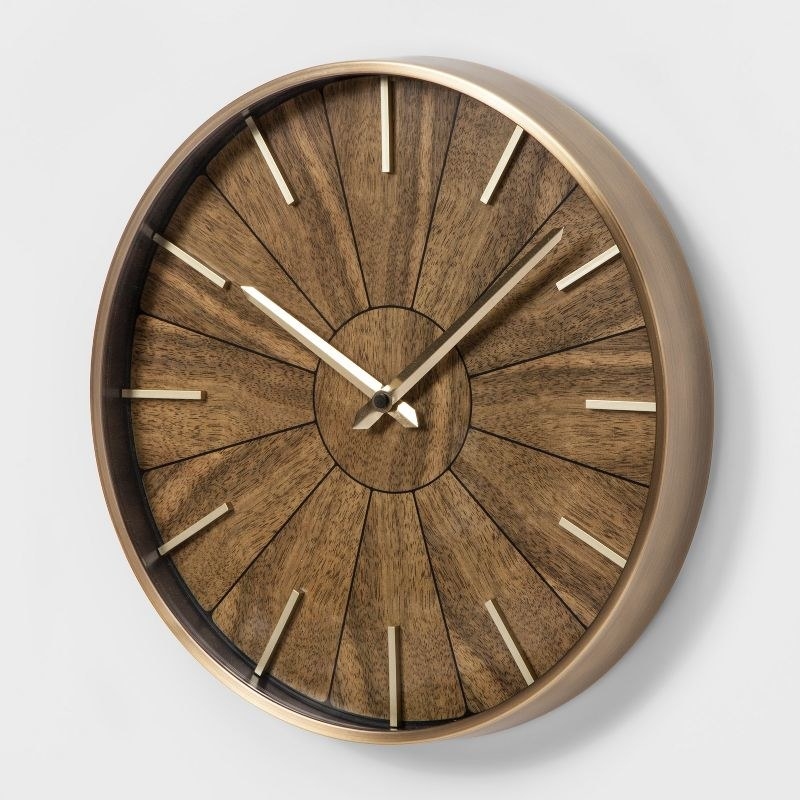 a walnut clock with brushed gold accents