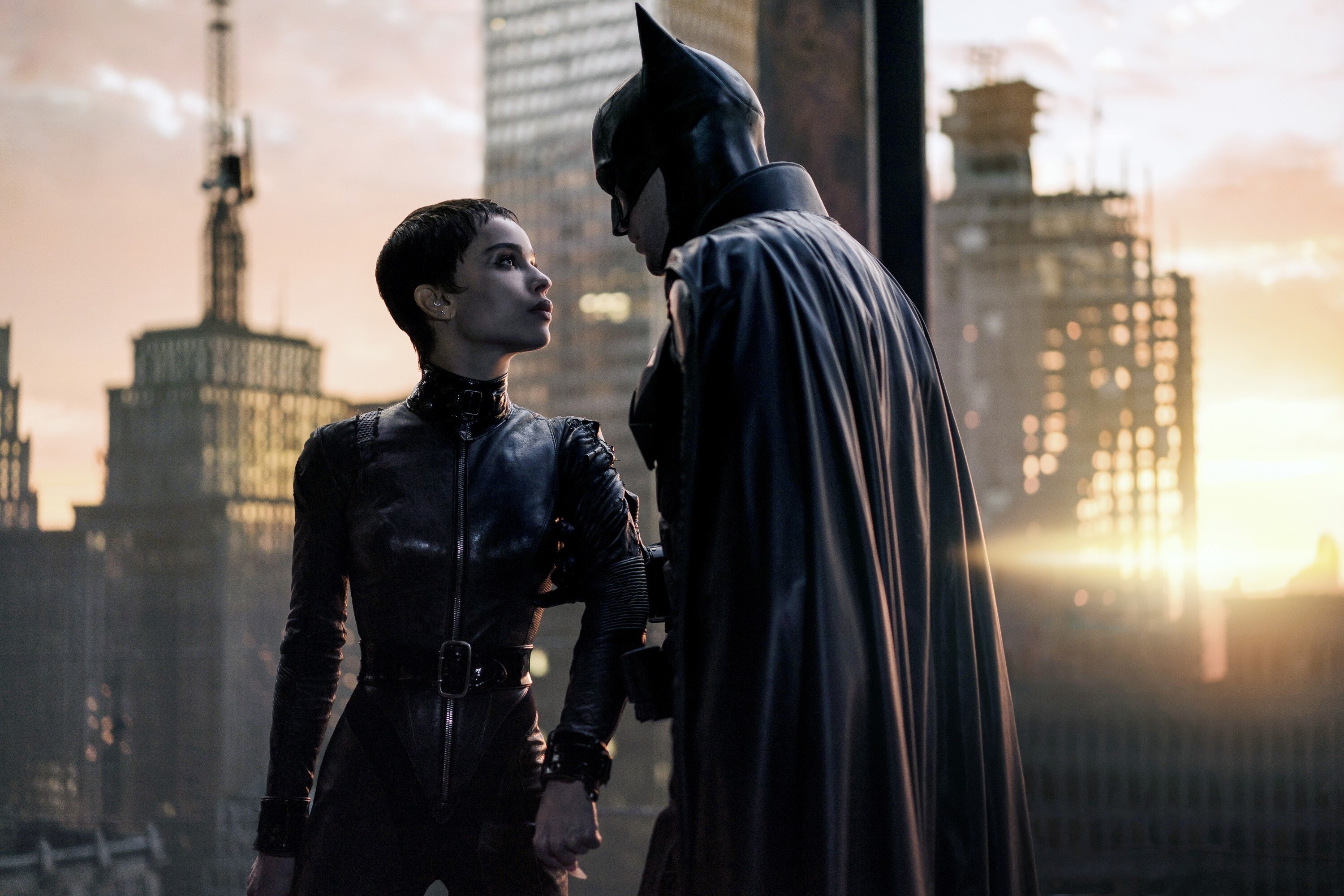 Zoe Kravitz and  Robert Pattinson as Catwoman and Batman staring each other down in front of the Gotham skyline