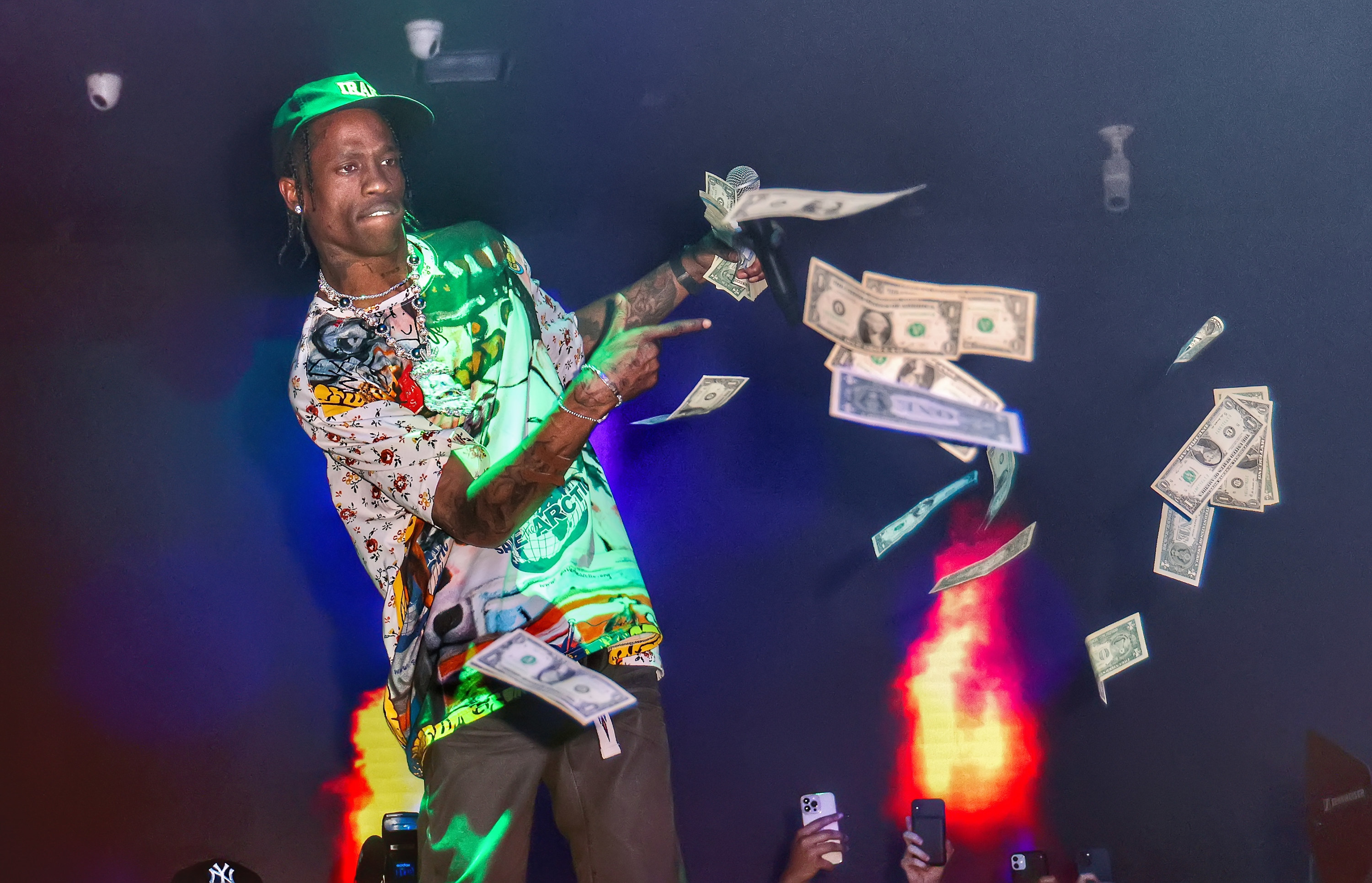 Travis Scott on stage throwing money at the crowd below