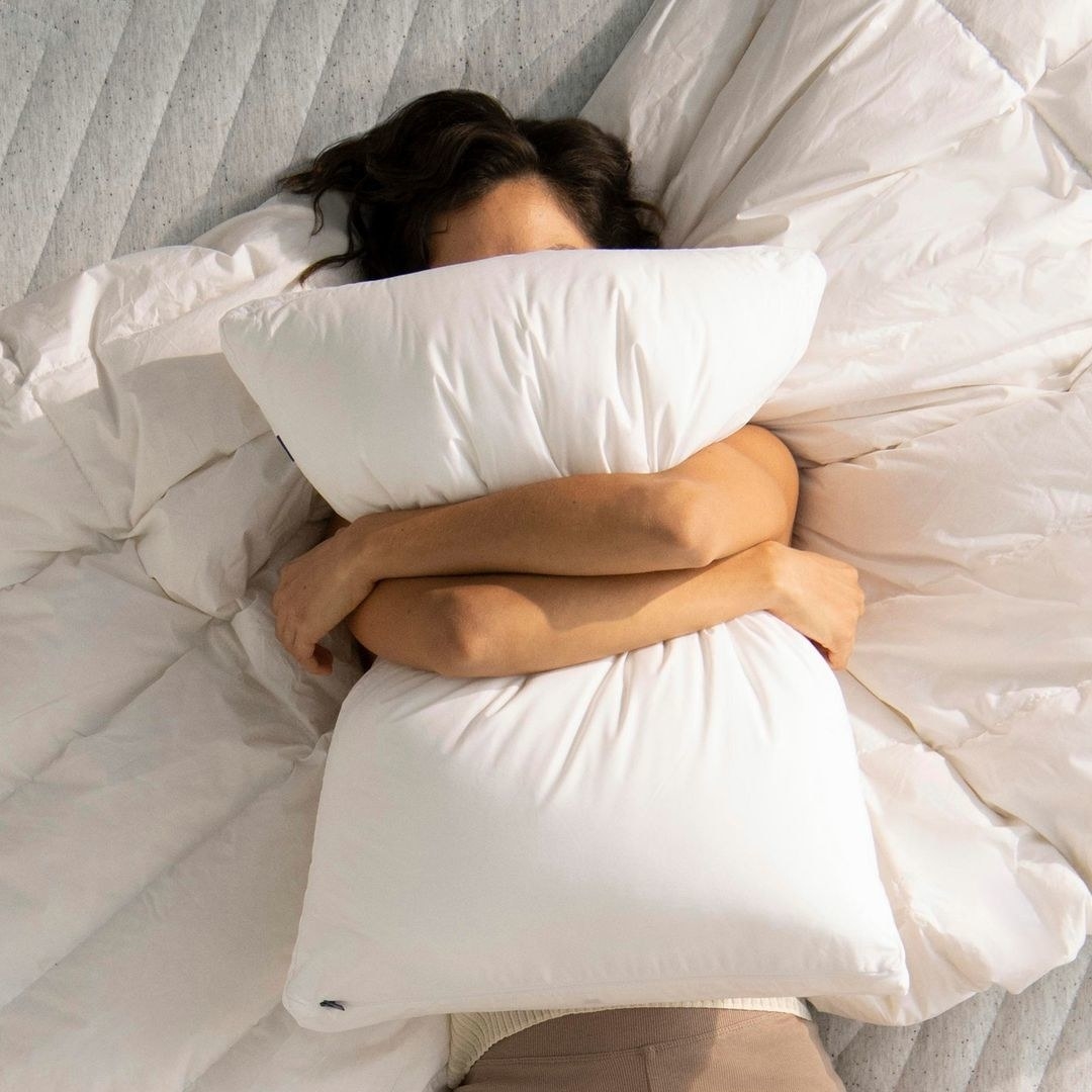 a top-down view of a person hugging the casper pillow