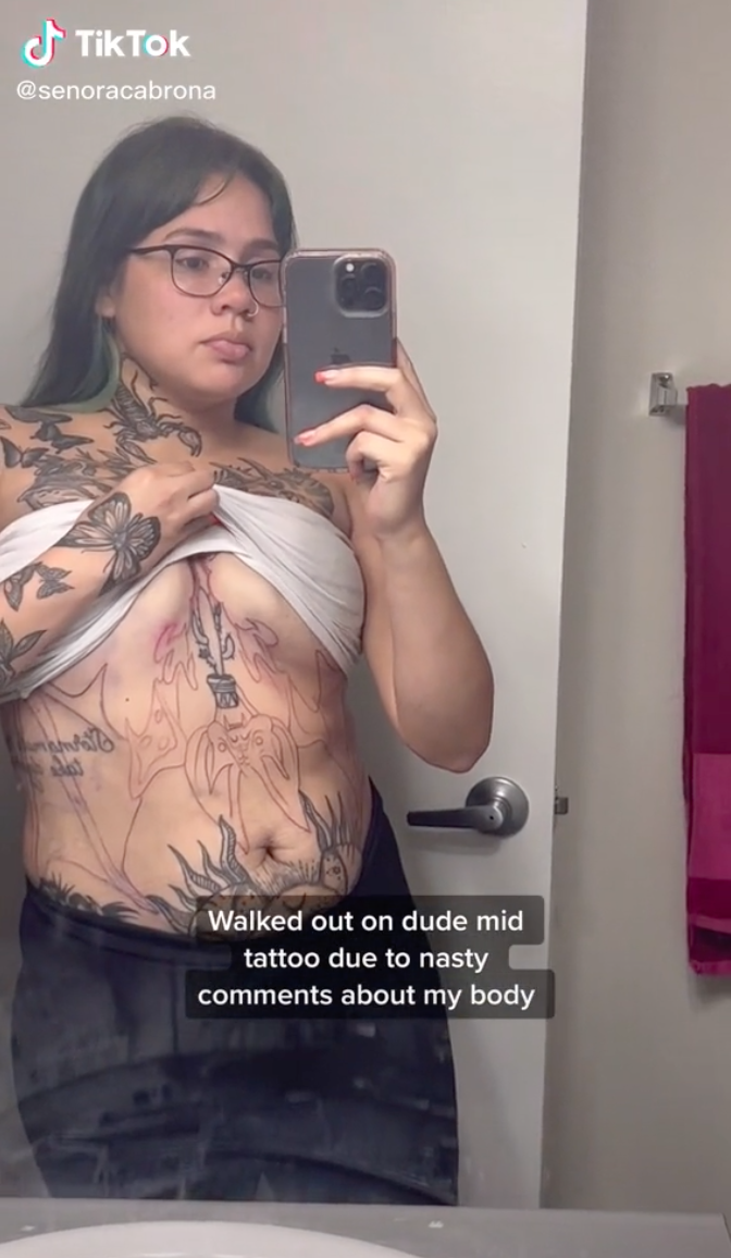 Dalina taking a selfie that shows the incomplete tattoo on her stomach