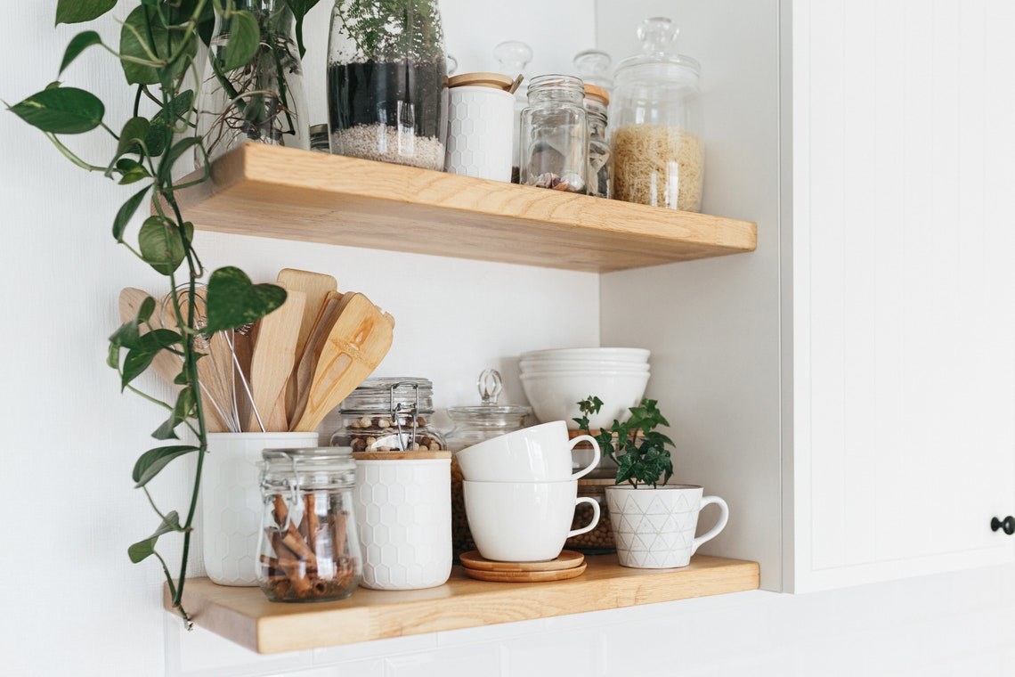 a pair of wooden shelves holding various kitchen supplies