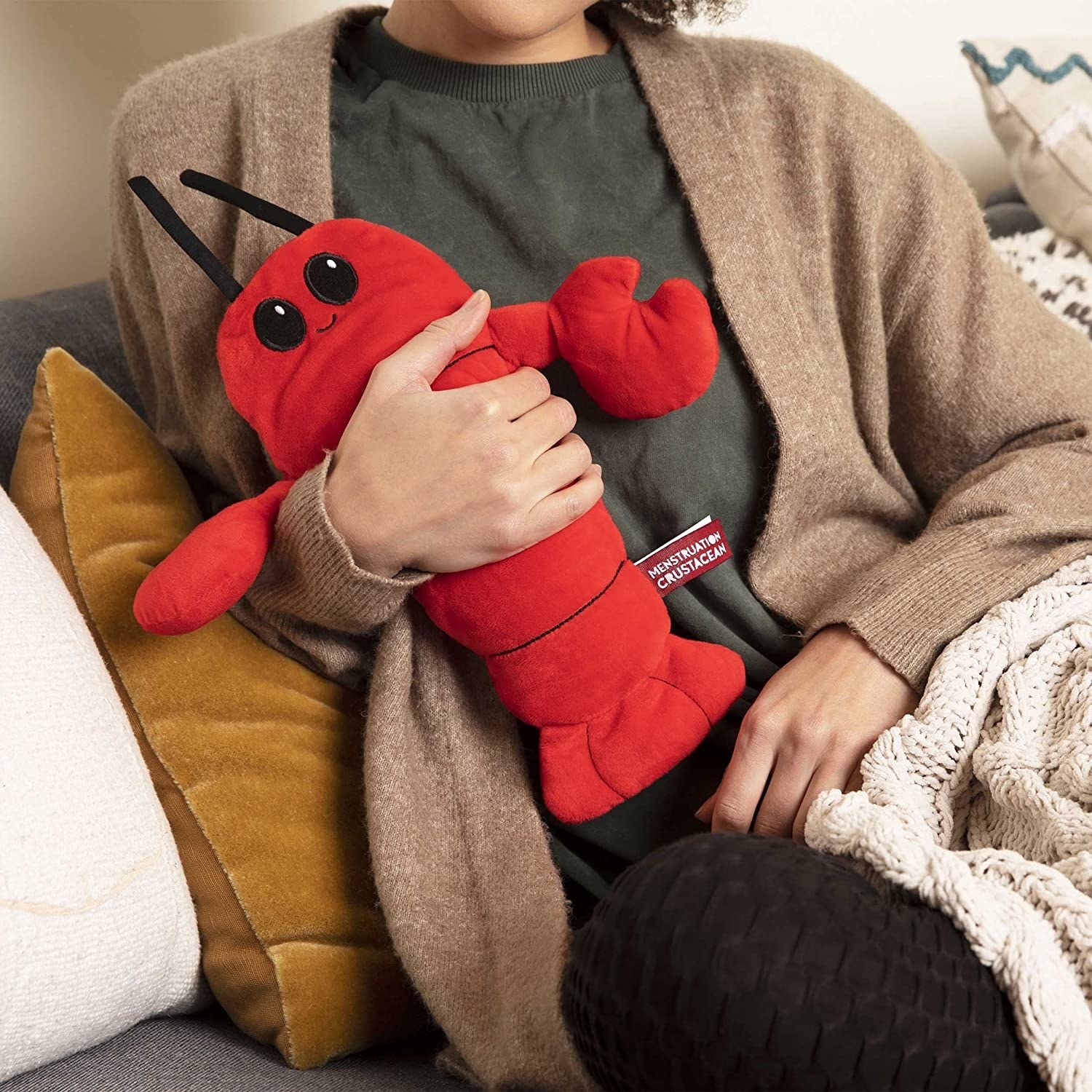 a person holding the lobster-shaped heating pad
