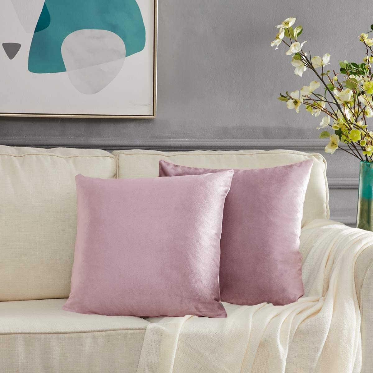 two throw pillows with satin covers on a couch