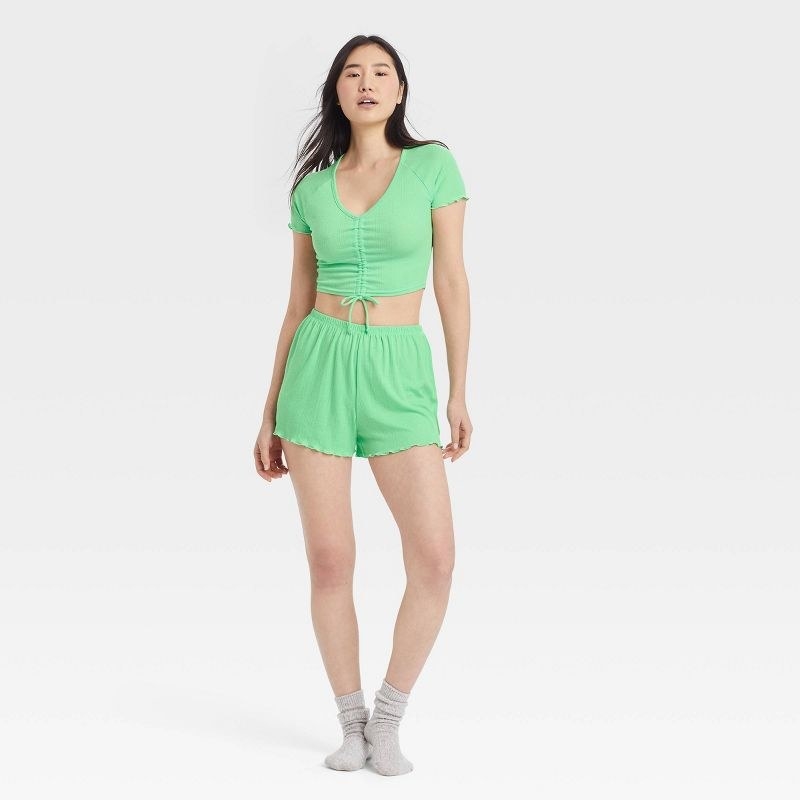 A model wearing the mint green matching shorts and shirt lounge set