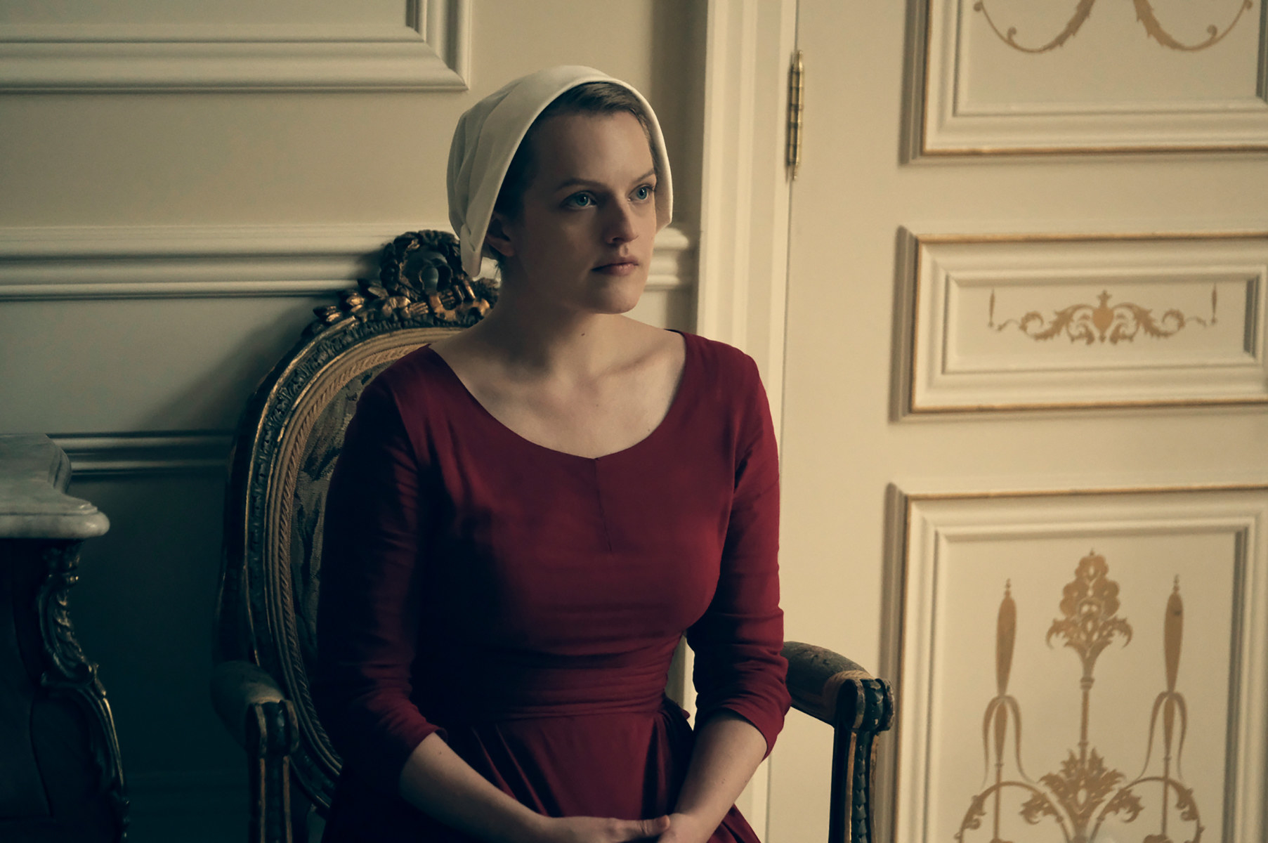 Elisabeth Moss sitting in a chair in &quot;The Handmaid&#x27;s Tale&quot;