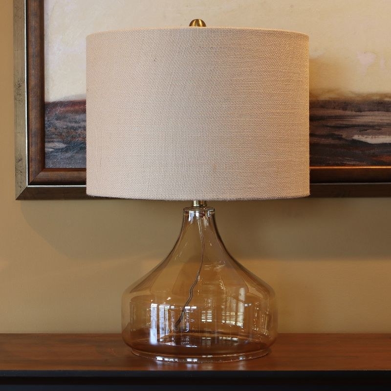 a glass table lamp on a side table