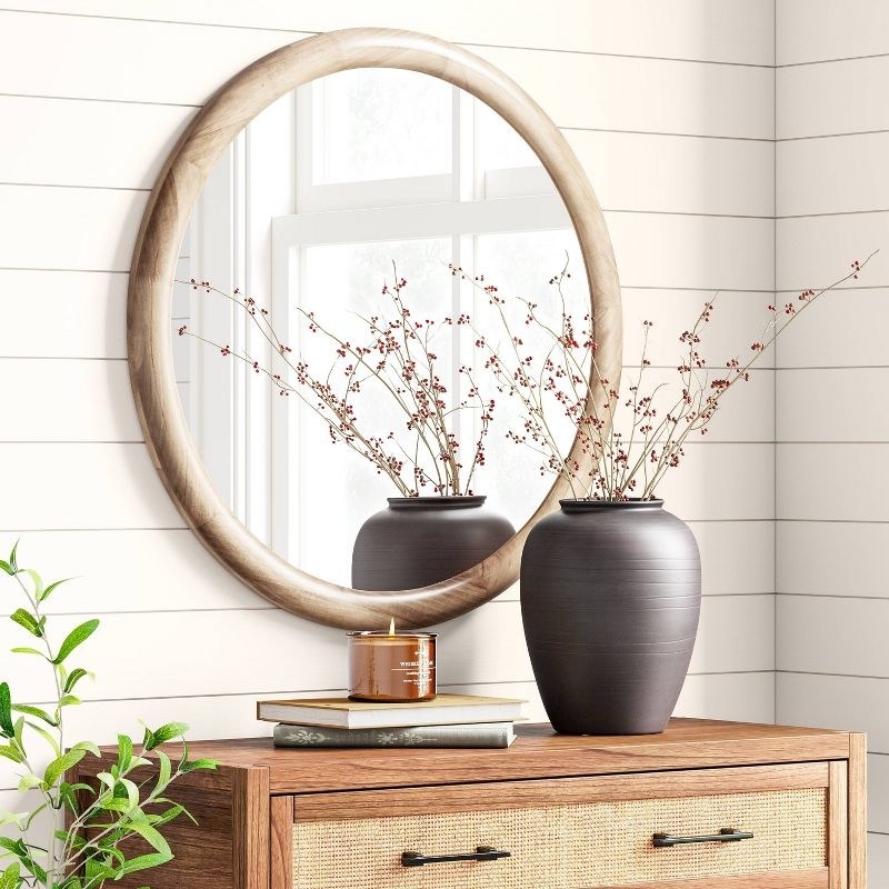 a round mirror over a side table