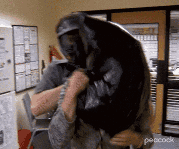 GIF of Dwight holding a garbage bag over Meredith&#x27;s head.