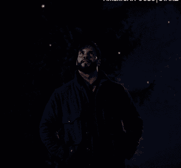 GIF of a man looking at fireflies in awe
