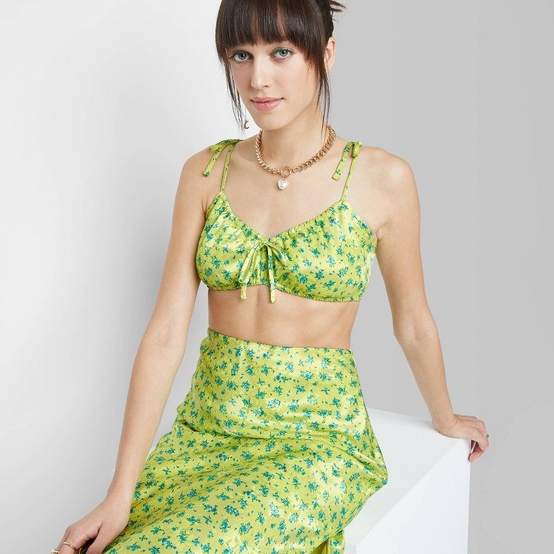 Model wearing green floral crop top with matching skirt