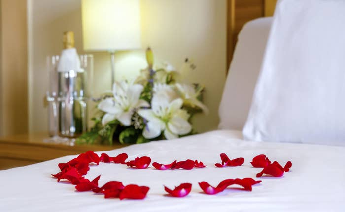 Rose petals on a hotel bed