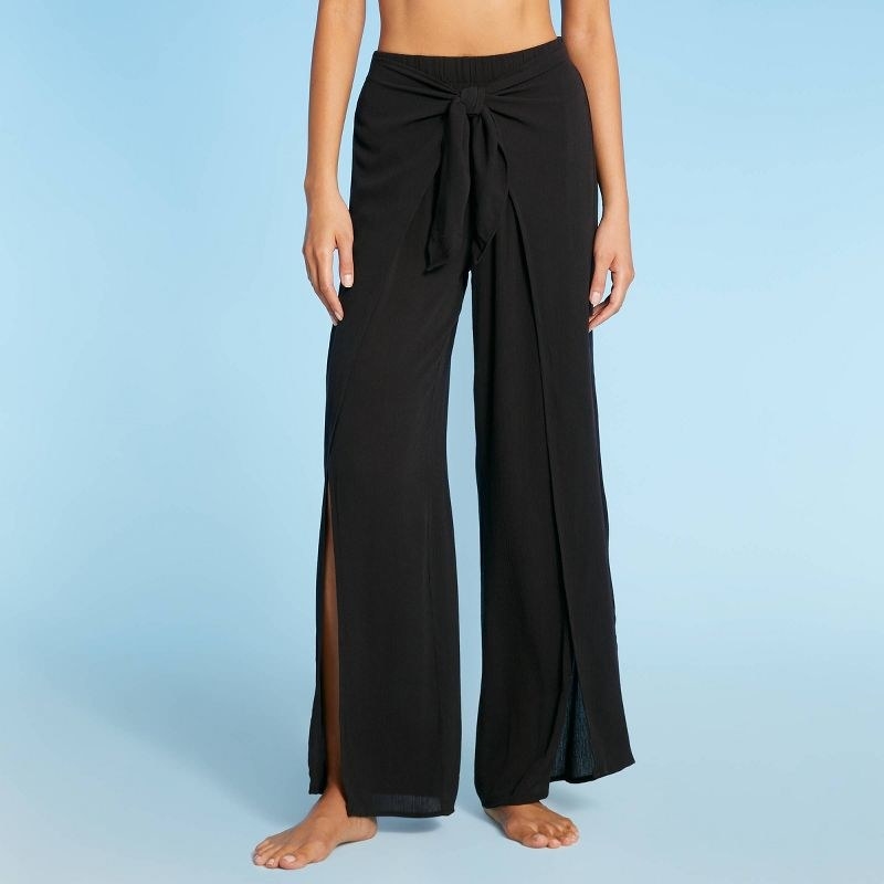Model wearing black tie-up cover-up pants