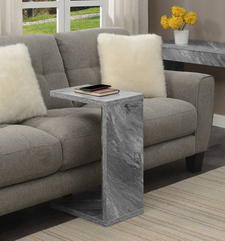 a marble end table over a grey couch