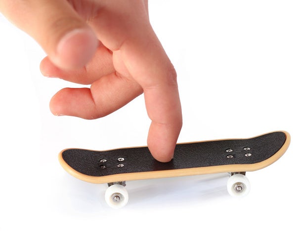 close up of a finger on a mini toy skateboard