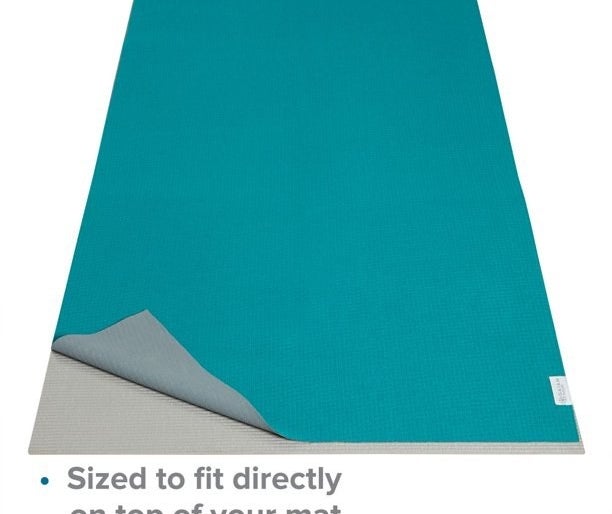 The teal towel on top of yoga mat with caption &quot;sized to fit directly on top of your mat&quot;
