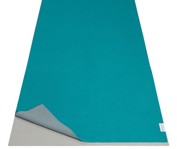 The teal towel on top of yoga mat with caption &quot;sized to fit directly on top of your mat&quot;
