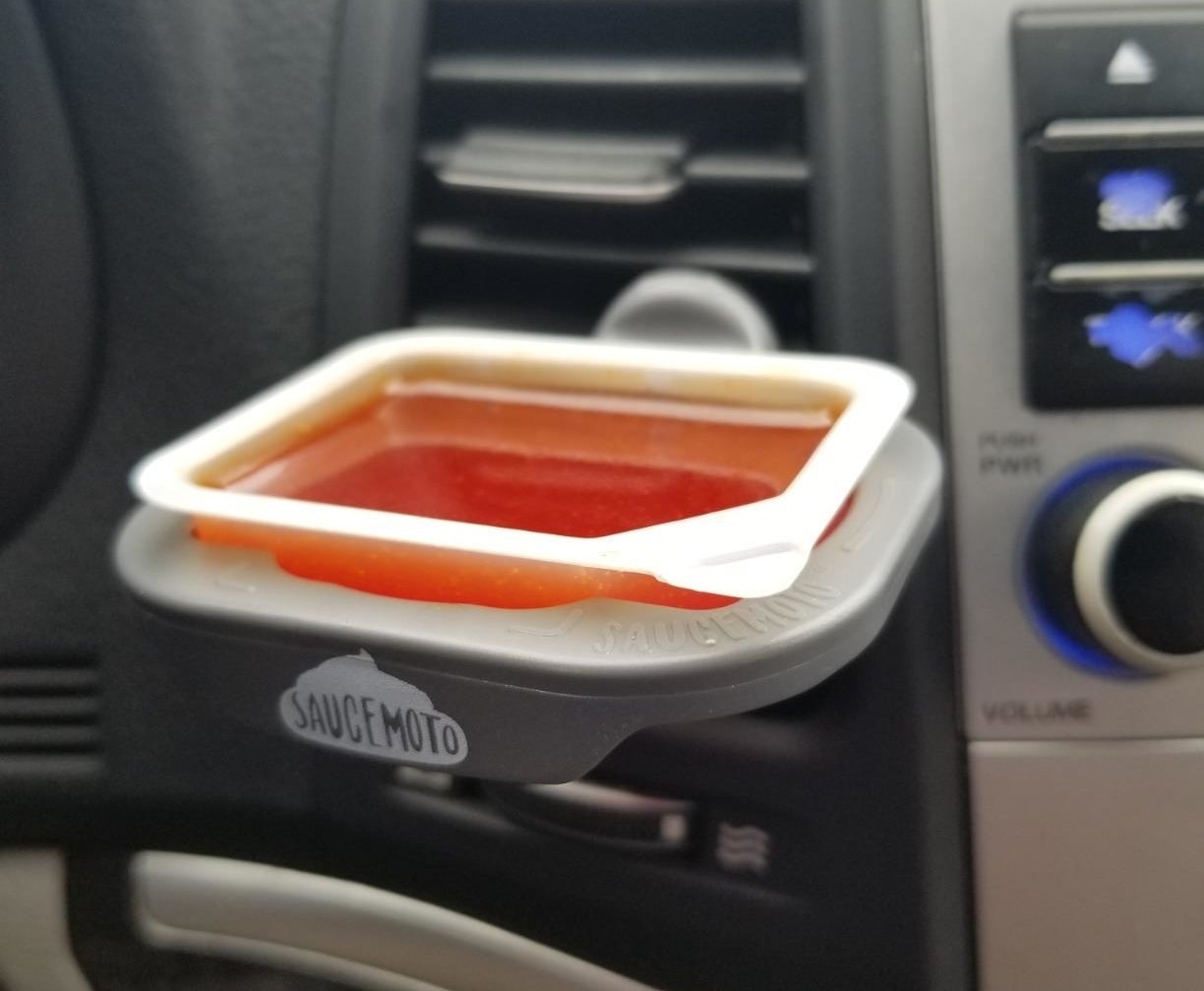 a reviewer&#x27;s dip clip holding a red sauce