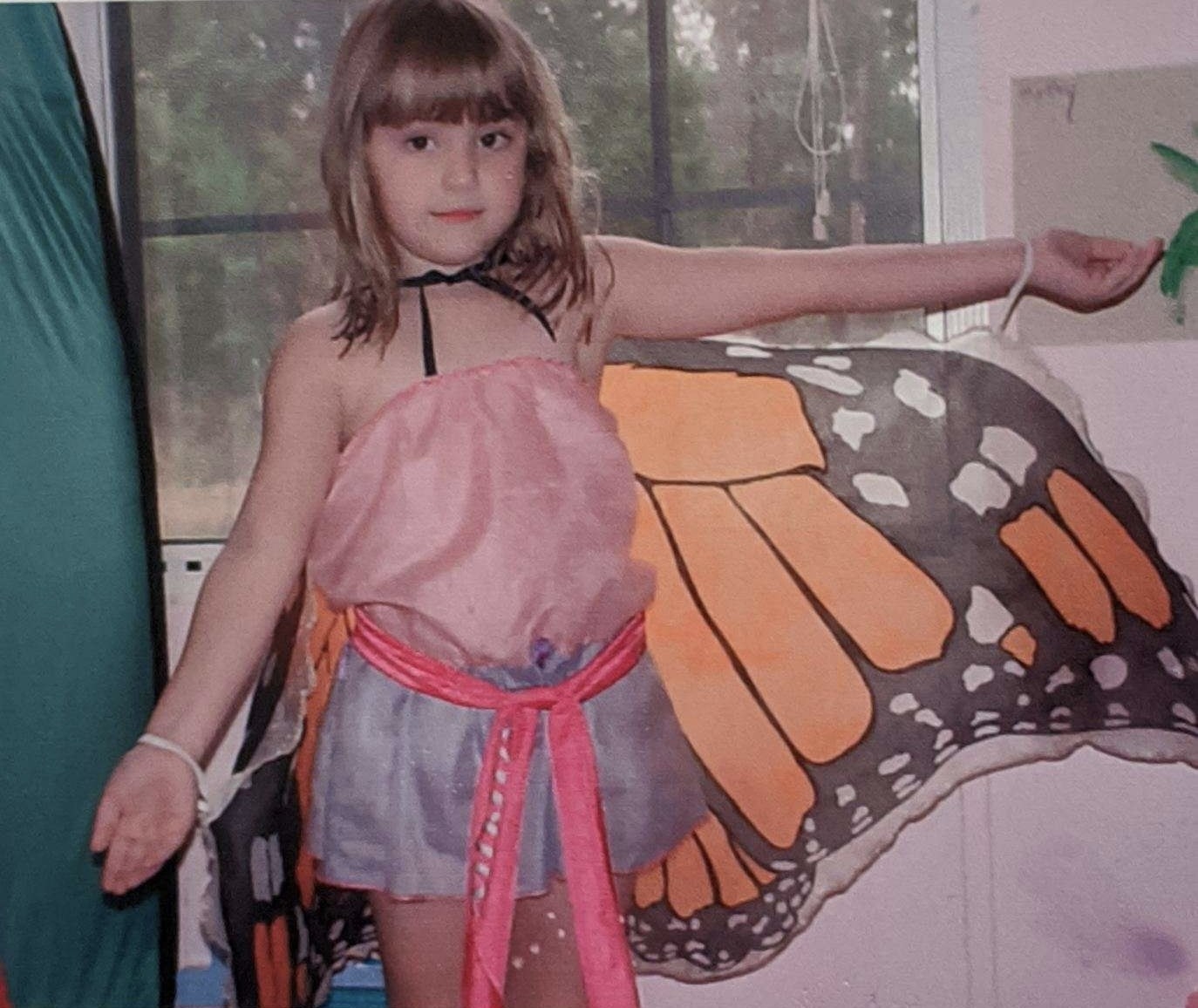 The author as a child wearing butterfly wings