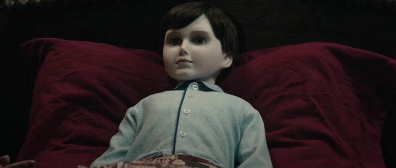 Boy doll on a pillow