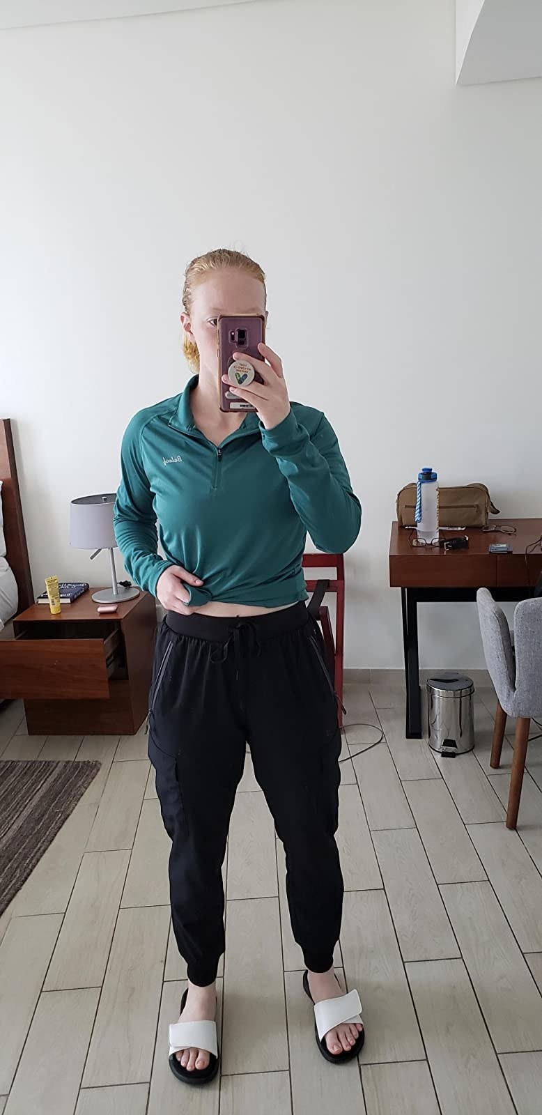 reviewer wearing the black drawstring waist joggers with white slide sandals