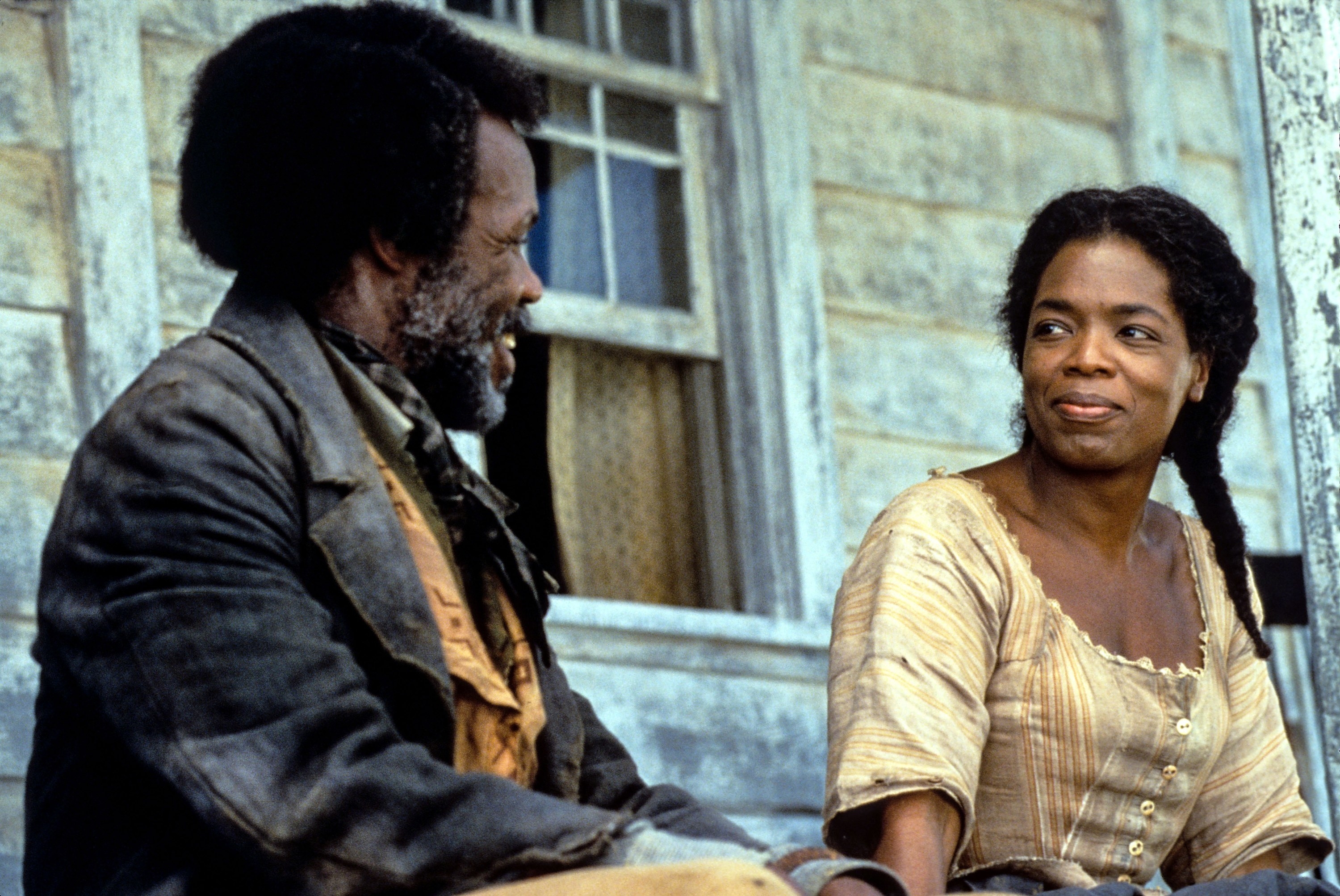 Danny Glover and Oprah Winfrey sit on a porch together