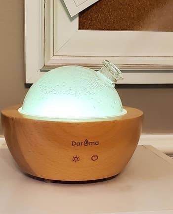 a reviewer's glass essential oil diffuser exhaling steam