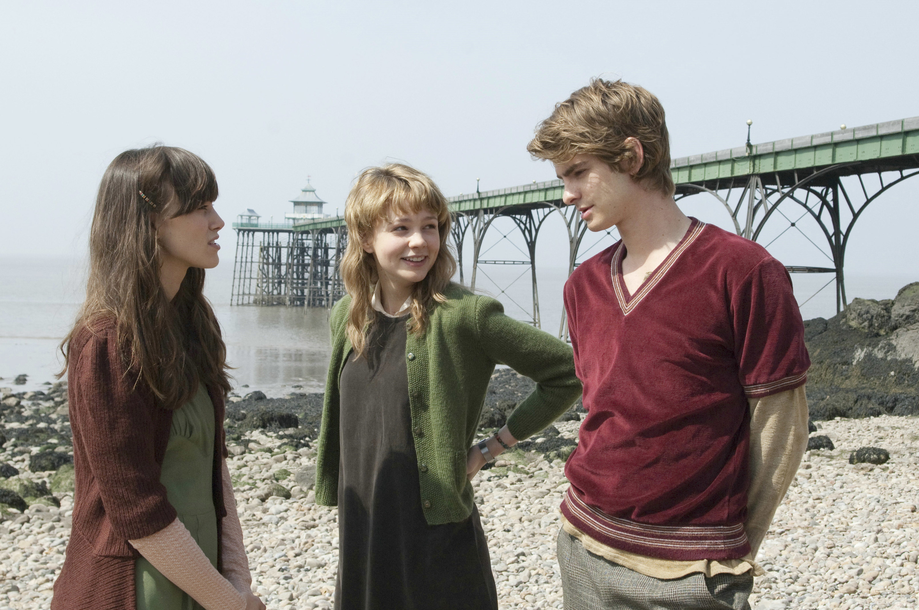 Keira Knightley, Carey Mulligan, and Andrew Garfield stand by the water