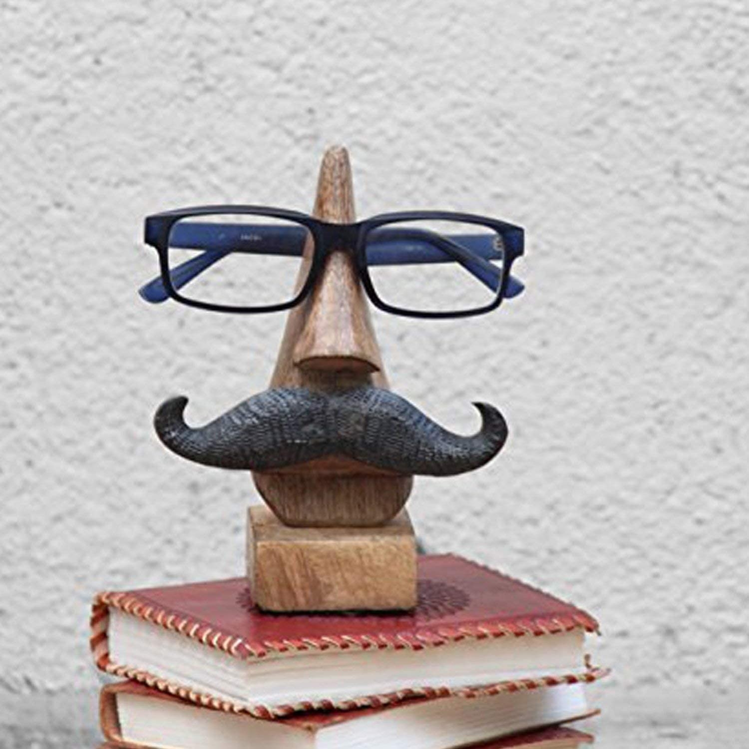 the glasses holder sitting on a stack of books