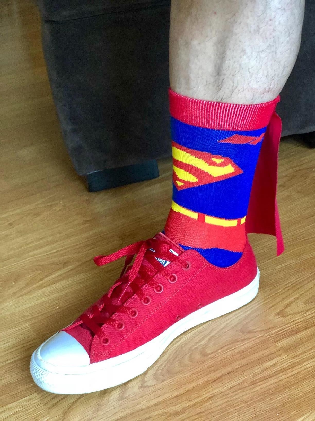 reviewer in superman sock with mini cape on the back