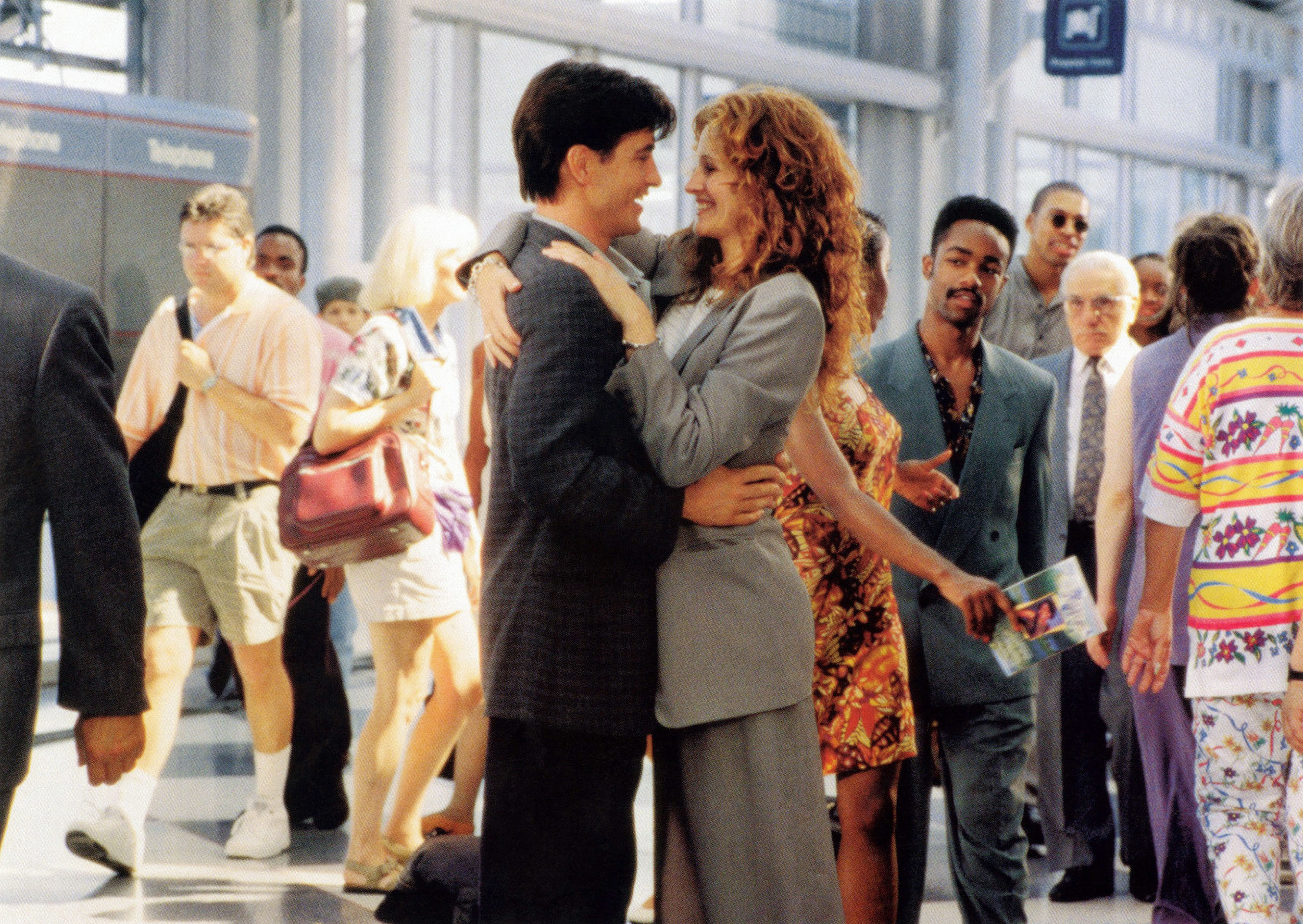 Dermot Mulroney and Julia Roberts in a crowded airport in a scene from the movie