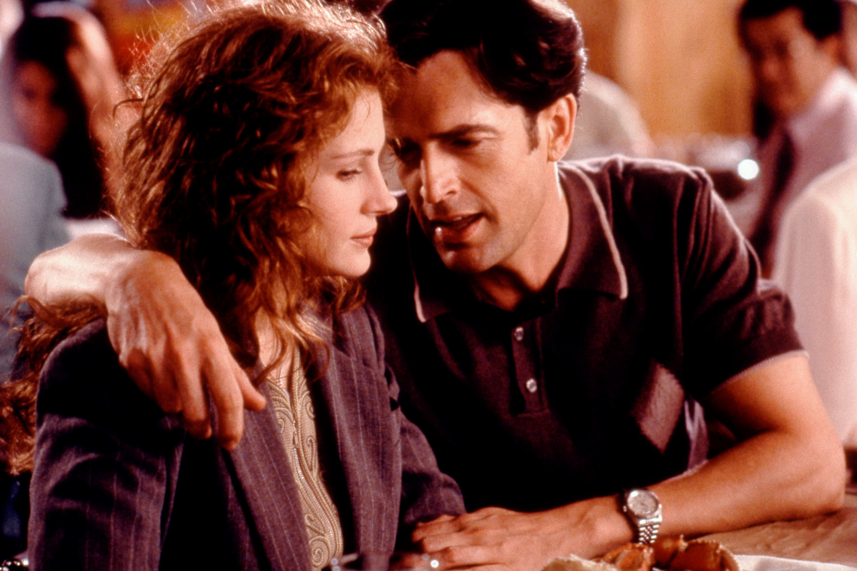 Julia Roberts and Rupert Everett sitting side by side, with Rupert&#x27;s arm around Julia&#x27;s shoulders