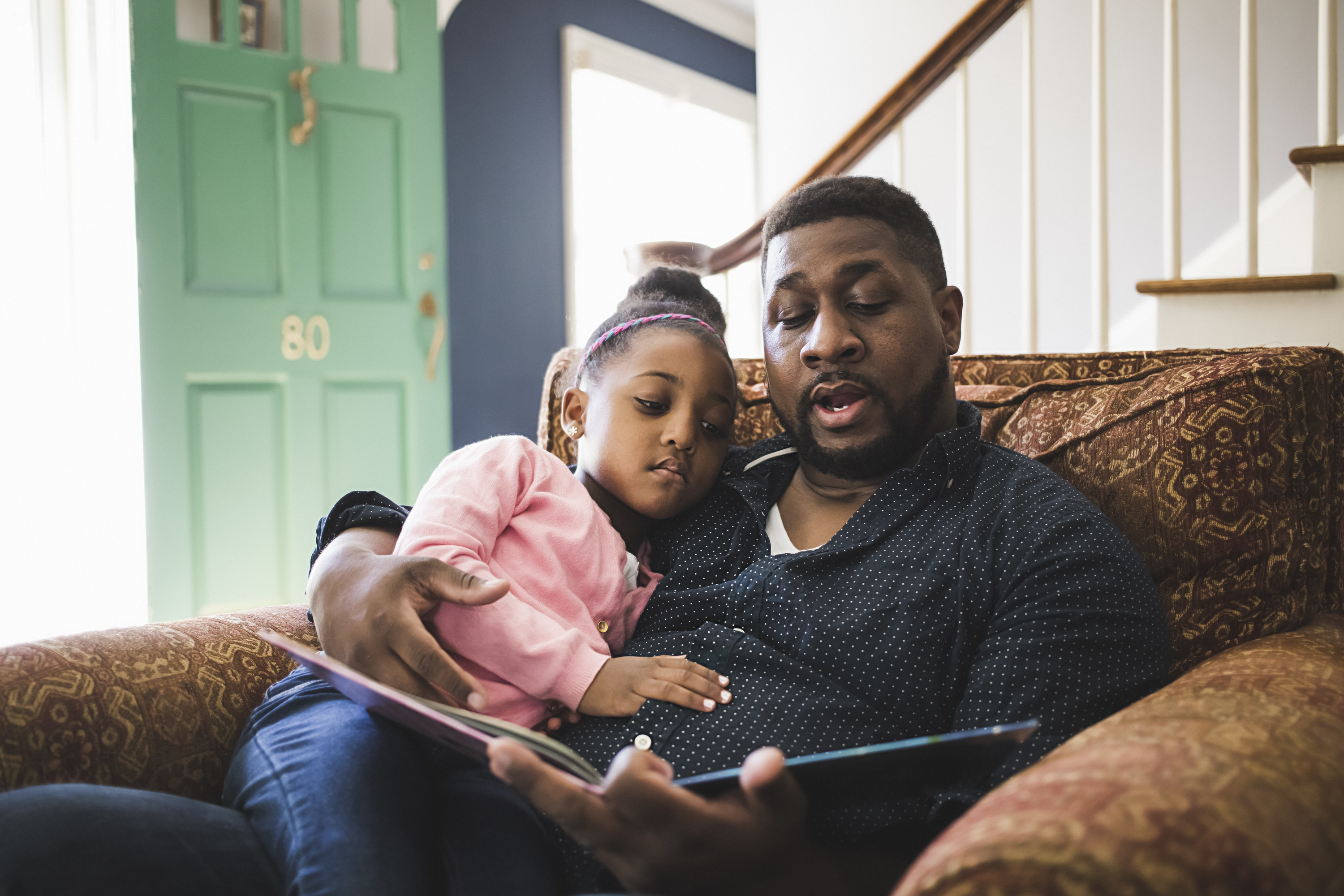 A dad reading a book to his child