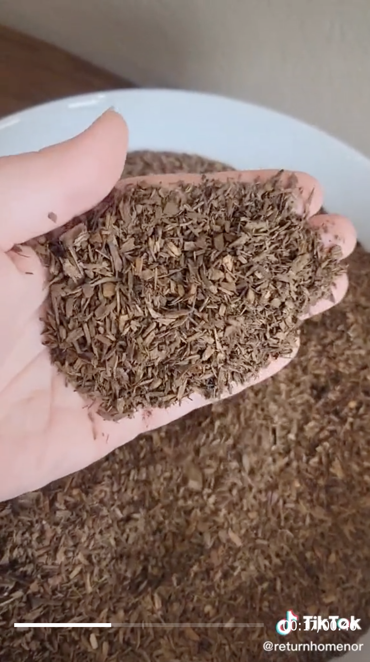 An image from Return Home&#x27;s TikTok that shows a hand holding compost chips