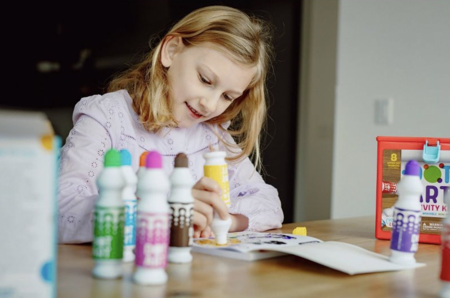 A kid using dot art markers